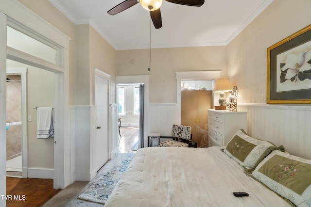 bedroom featuring ornamental molding, a wainscoted wall, ceiling fan, and wood finished floors
