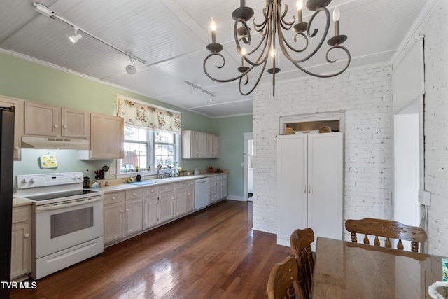 kitchen with an inviting chandelier, under cabinet range hood, rail lighting, white appliances, and dark wood finished floors