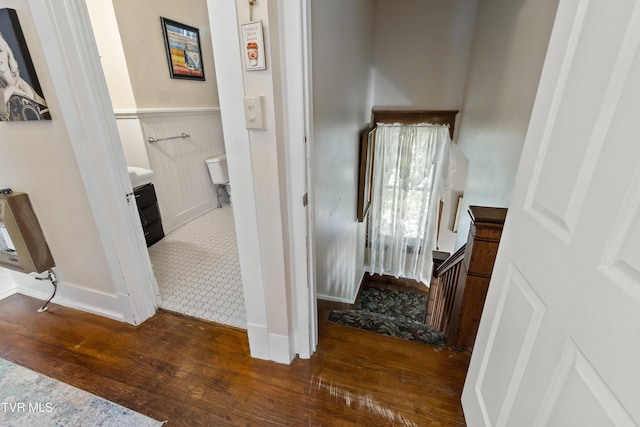 interior space with baseboards, wainscoting, hardwood / wood-style flooring, and stairs