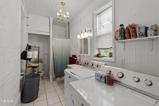 laundry room with a chandelier, light tile patterned floors, separate washer and dryer, laundry area, and crown molding
