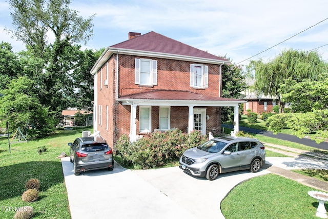 view of front facade with concrete driveway, a chimney, a front lawn, and brick siding