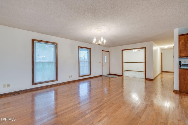 120 Lynnwood Dr, Johnson City, TN 37615 - empty room with light wood-style flooring, visible vents, an inviting chandelier, and a textured ceiling