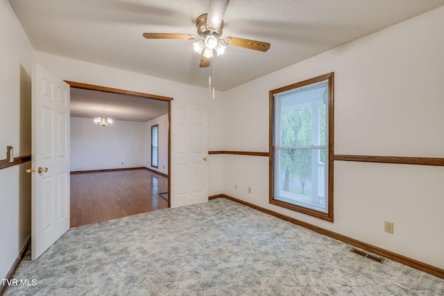 120 Lynnwood Dr, Johnson City, TN 37615 - carpeted empty room with visible vents, baseboards, a textured ceiling, and ceiling fan with notable chandelier
