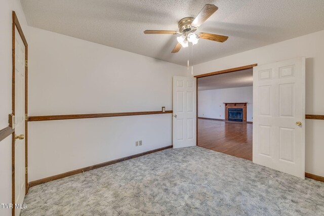 120 Lynnwood Dr, Johnson City, TN 37615 - carpeted empty room with a fireplace, a textured ceiling, baseboards, and ceiling fan