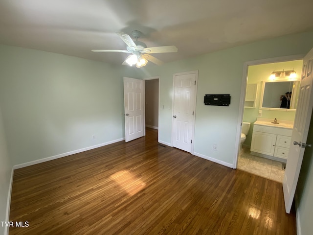 158 Taylortown Rd, Johnson City, TN 37601 - unfurnished bedroom with ensuite bathroom, baseboards, a sink, a ceiling fan, and dark wood finished floors
