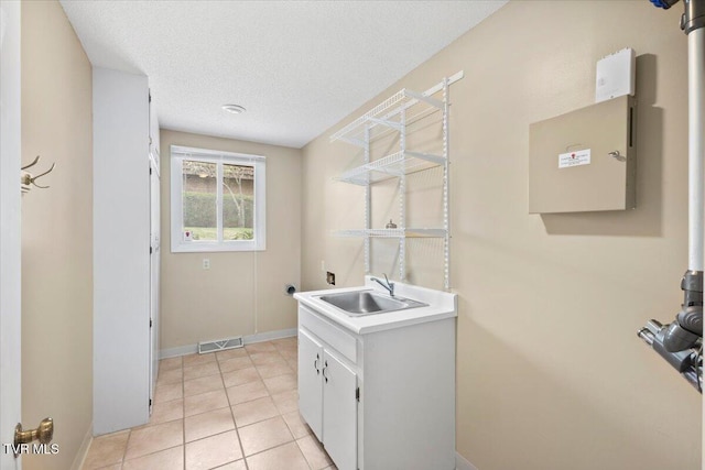 909 Millercrest Dr, Johnson City, TN 37604 - washroom with visible vents, baseboards, light tile patterned floors, a sink, and cabinet space
