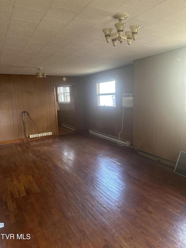 714 Fairview Ave, Kingsport, TN 37660 - spare room with wood walls, a baseboard radiator, an inviting chandelier, and wood finished floors