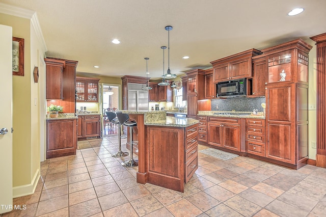 216 Forest Hills Dr, Bristol, TN 37620 - kitchen featuring glass insert cabinets, black microwave, a kitchen island, a breakfast bar, and decorative backsplash