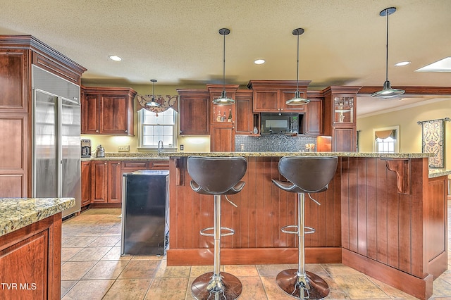 216 Forest Hills Dr, Bristol, TN 37620 - kitchen featuring tasteful backsplash, black microwave, stainless steel built in refrigerator, a breakfast bar area, and hanging light fixtures