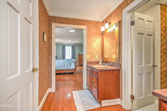 216 Forest Hills Dr, Bristol, TN 37620 - ensuite bathroom with ornamental molding, wallpapered walls, vanity, and a textured ceiling