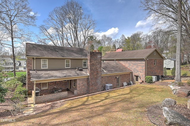 216 Forest Hills Dr, Bristol, TN 37620 - rear view of house with a chimney, a lawn, cooling unit, brick siding, and a shingled roof