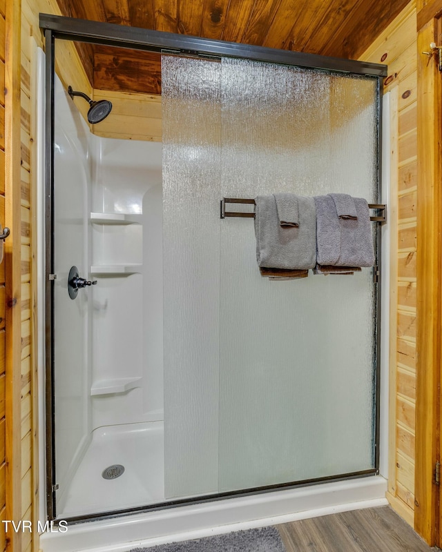 full bathroom featuring wooden walls, wooden ceiling, and a stall shower