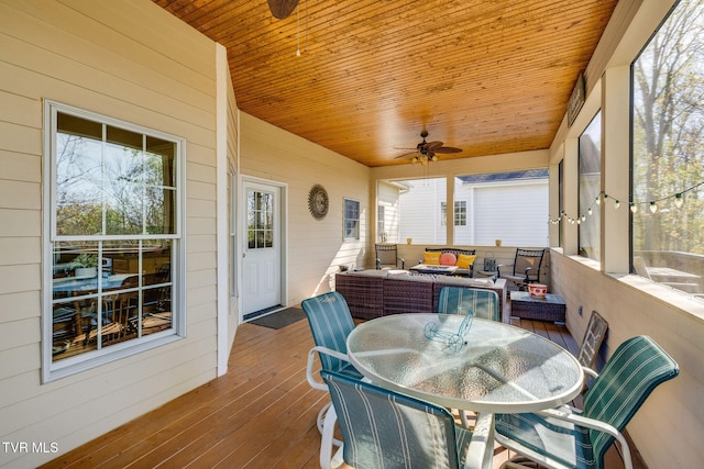 sunroom with outdoor lounge area, outdoor dining space, a ceiling fan, and plenty of natural light