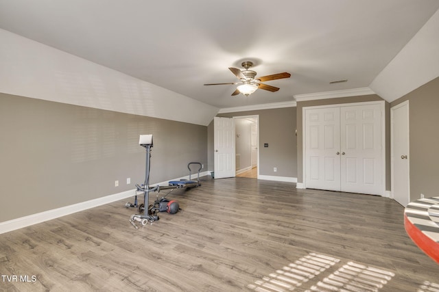 workout room featuring ceiling fan, visible vents, wood finished floors, lofted ceiling, and baseboards