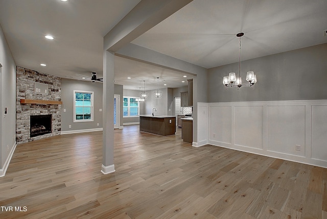 2442 Haystack Cir, Piney Flats, TN 37686 - unfurnished living room with a chandelier, light wood-style flooring, ceiling fan, a fireplace, and recessed lighting
