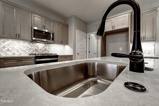 2442 Haystack Cir, Piney Flats, TN 37686 - kitchen with appliances with stainless steel finishes, light stone counters, and backsplash