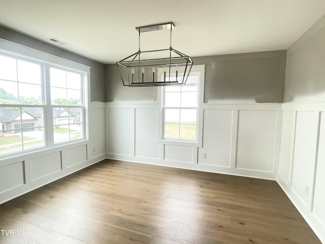 4076 Maize Pl, Piney Flats, TN 37686 - unfurnished dining area featuring a decorative wall, wainscoting, a chandelier, healthy amount of natural light, and wood finished floors