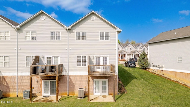 rear view of property with a yard, brick siding, french doors, and cooling unit