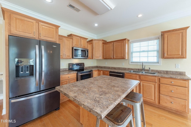kitchen with visible vents, a sink, ornamental molding, stainless steel appliances, and a breakfast bar area
