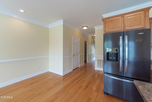 kitchen featuring light wood-style flooring, ornamental molding, visible vents, stainless steel refrigerator with ice dispenser, and baseboards