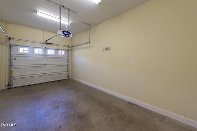 garage with baseboards and a garage door opener