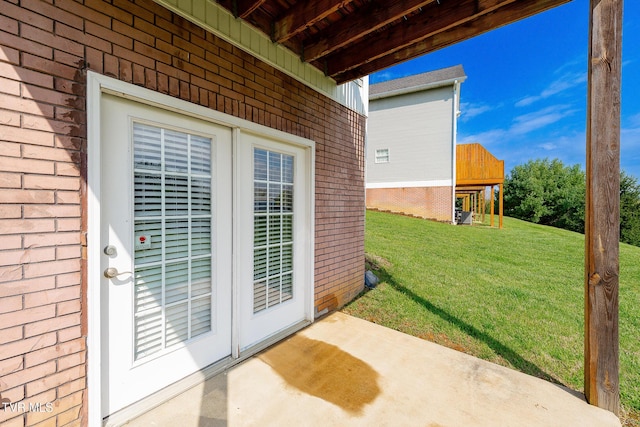 doorway to property with a lawn and brick siding