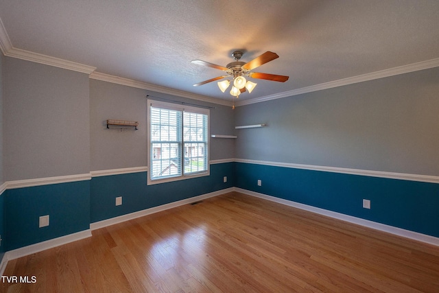 spare room featuring ceiling fan, baseboards, ornamental molding, and wood finished floors