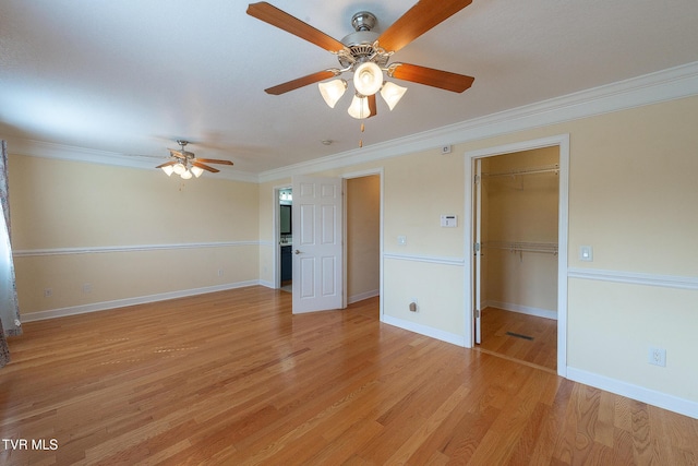 empty room with light wood-style flooring, ceiling fan, crown molding, and baseboards
