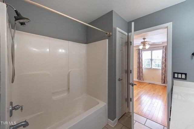full bathroom featuring shower / bath combination, ceiling fan, a sink, and tile patterned floors