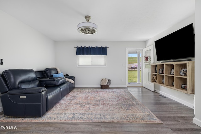 living room featuring visible vents, baseboards, and wood finished floors