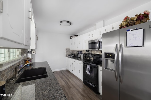 kitchen with a sink, dark wood-style flooring, appliances with stainless steel finishes, white cabinetry, and decorative backsplash