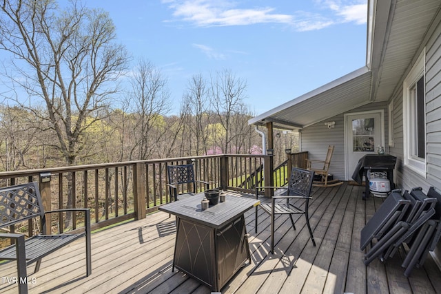 wooden terrace featuring a grill and a fire pit