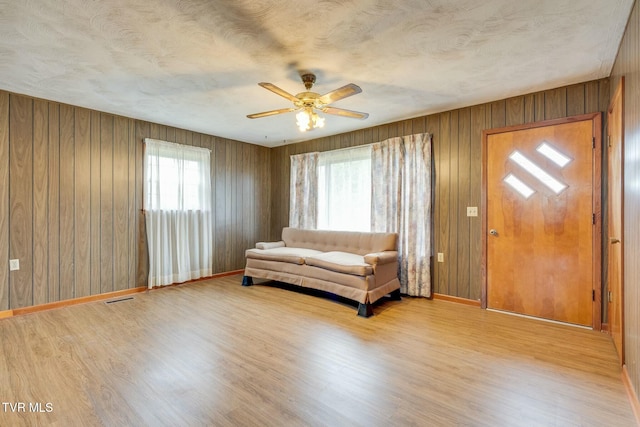 unfurnished room with light wood-style flooring, a ceiling fan, and a textured ceiling