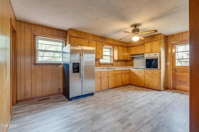 kitchen with light wood-style flooring, light countertops, a ceiling fan, visible vents, and stainless steel appliances