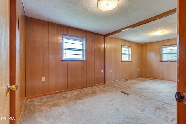 spare room with plenty of natural light, visible vents, baseboards, and carpet floors