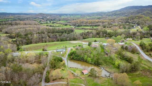 drone / aerial view with a forest view and a water and mountain view