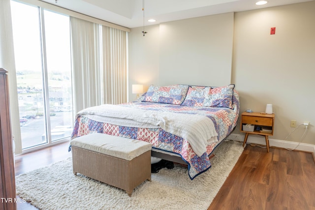 bedroom with wood finished floors, baseboards, and recessed lighting