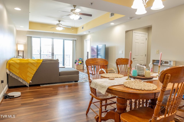 dining space featuring a tray ceiling, wood finished floors, a ceiling fan, recessed lighting, and baseboards
