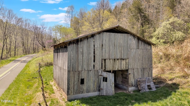 view of barn with a forest view