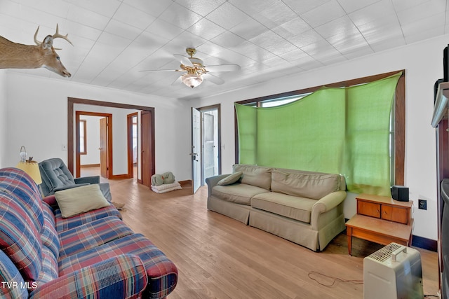 living room featuring ceiling fan, wood finished floors, and baseboards