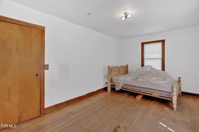bedroom with wood finished floors and baseboards