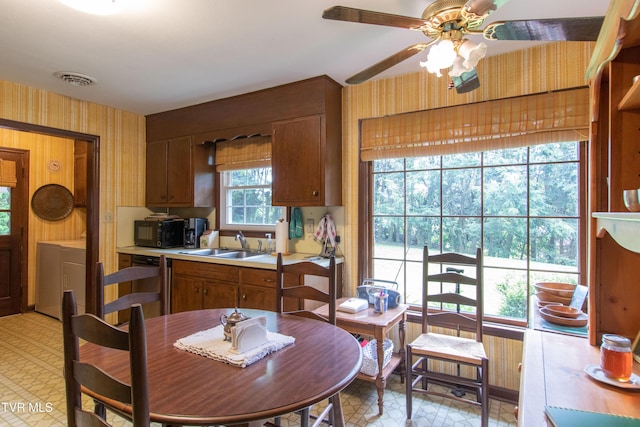 19494 Oakwood Dr, Abingdon, VA 24211 - kitchen with a sink, wallpapered walls, black microwave, washing machine and clothes dryer, and light countertops