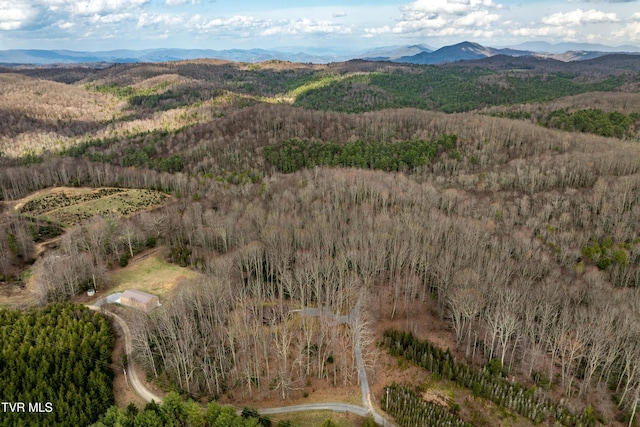birds eye view of property with a wooded view and a mountain view