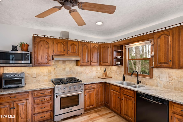 kitchen with brown cabinets, under cabinet range hood, a sink, and stainless steel appliances