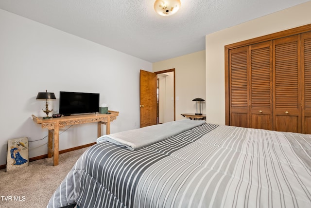 bedroom featuring a closet, baseboards, carpet flooring, and a textured ceiling