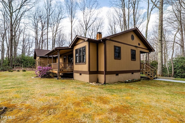 view of side of home featuring a yard, crawl space, and a chimney