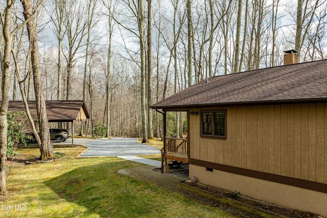 view of yard featuring a carport and driveway