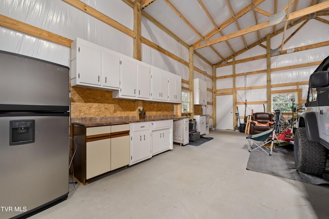 garage with metal wall and stainless steel refrigerator with ice dispenser