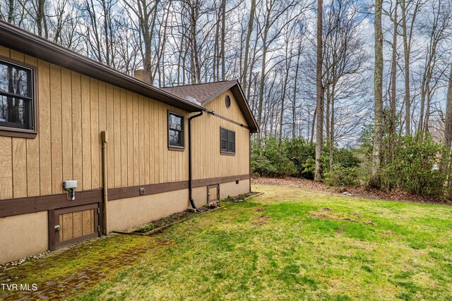view of side of property featuring a chimney and a lawn