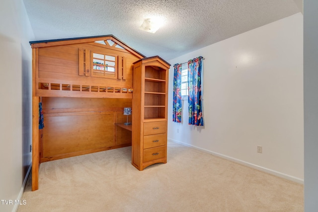 bedroom featuring baseboards, a textured ceiling, carpet flooring, and lofted ceiling